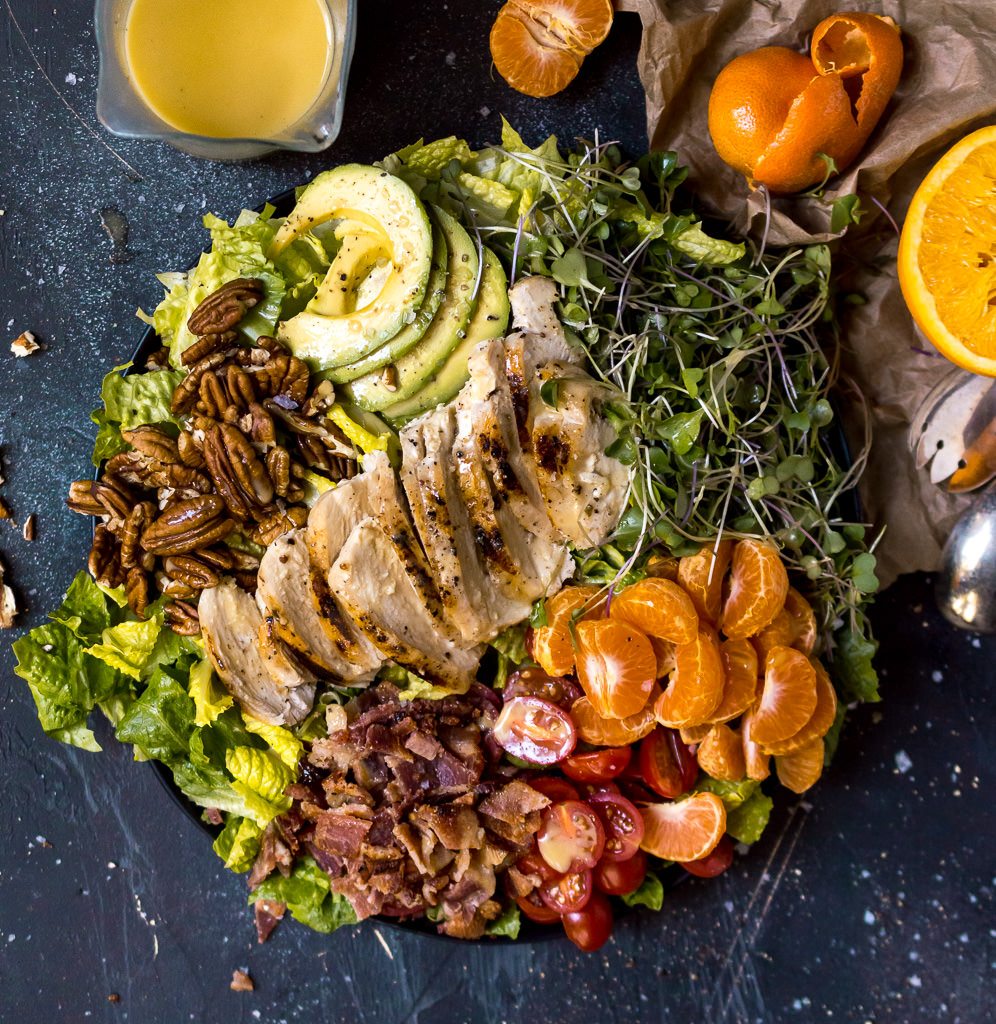salad filled with chicken, oranges, bacon, pecans and avocado