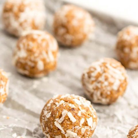 round energy balls with coconut flakes on wax paper