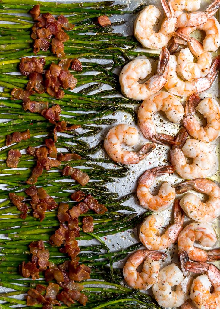 asparagus, bacon and shrimp arranged on a sheet pan 