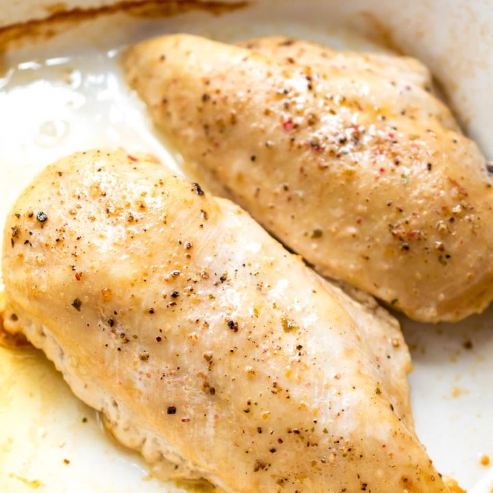 oven baked chicken breast topped with salt and pepper in white baking dish
