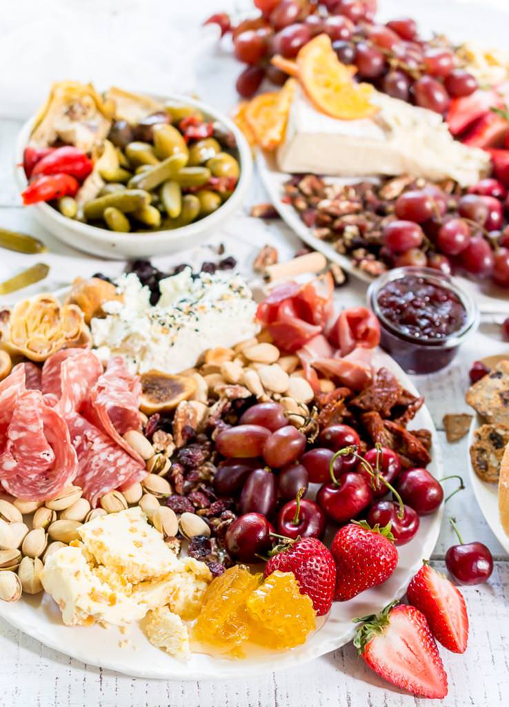 Throw an EPIC Summer Party without even turning your oven on! This Charcuterie Board and Orange 75 Cocktails are perfect for entertaining. The cheese platter is is loaded with meats, cheeses, crackers, fruits, nuts and more. And this simple cocktail recipe is sure to impress your guests! #entertaining #partyideas #cheeseboard #cocktailrecipes
