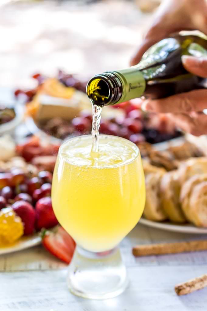 Throw an EPIC Summer Party without even turning your oven on! This Charcuterie Board and Orange 75 Cocktails are perfect for entertaining. The cheese platter is is loaded with meats, cheeses, crackers, fruits, nuts and more. And this simple cocktail recipe is sure to impress your guests! #entertaining #partyideas #cheeseboard #cocktailrecipes