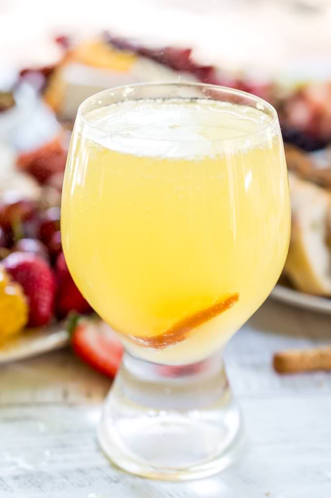 Throw an EPIC Summer Party without even turning your oven on! This Charcuterie Board and Orange 75 Cocktails are perfect for entertaining. The cheese platter is is loaded with meats, cheeses, crackers, fruits, nuts and more. And this simple cocktail recipe is sure to impress your guests! #entertaining #partyideas #cheeseboard #cocktailrecipes