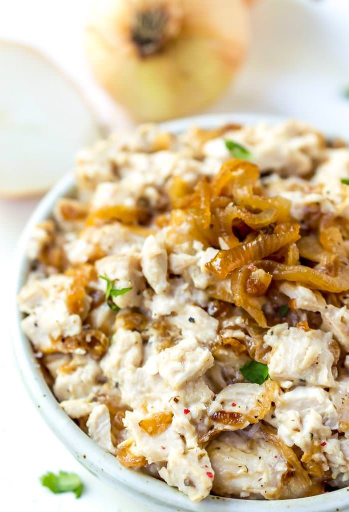 close up photo of caramelized onion paleo chicken salad with white onions in the background
