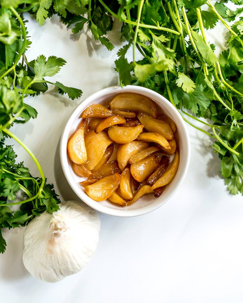 close up photo of roasted garlic and cilantro for chimichurri sauce recipe