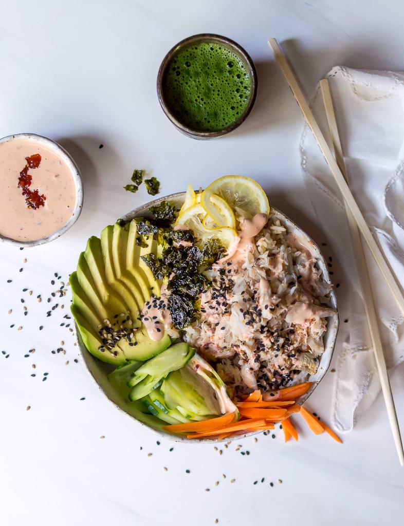 overhead photo of sushi bowl, macho tea, chopsticks and a mini bowl of spicy sauce