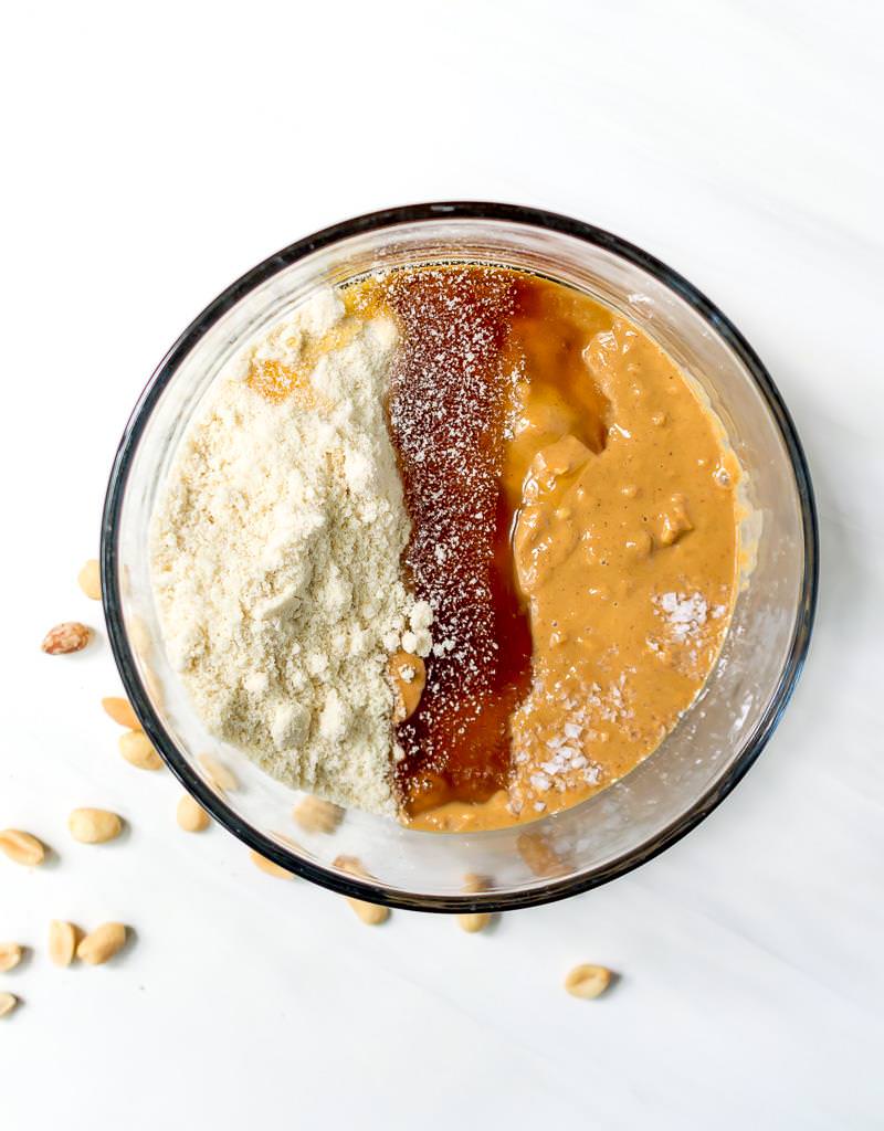 over head photo of peanut butter protein balls ingredients in clear glass bowl