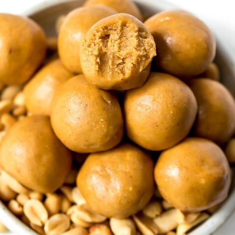 close up photo of peanut butter protein balls, one has a bite taken out
