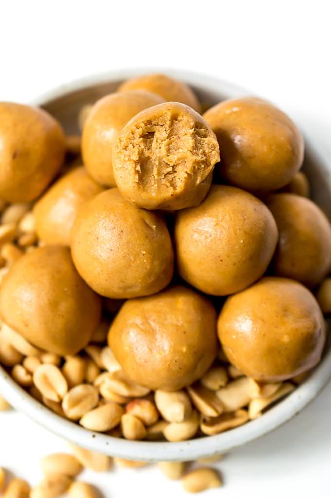 close up photo of peanut butter protein balls, one has a bite taken out