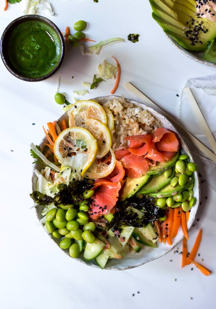 over head photo of salmon sushi roll bowl with mocha green tea and chopsticks on the side