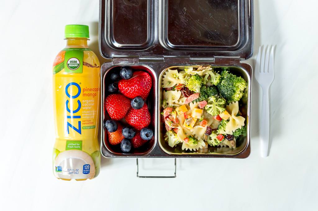 metal lunchbox with broccoli salad recipe and fresh strawberries inside