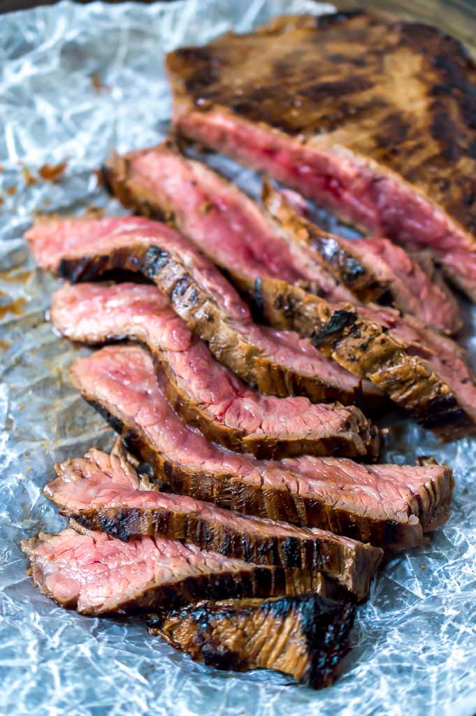 close up photo of sliced flank steak recipe with a slightly charred crust and red-pink in the middle