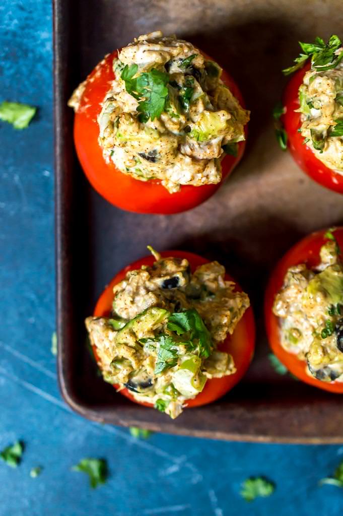 over head view of taco tuna stuffed tomatoes on brown baking dish
