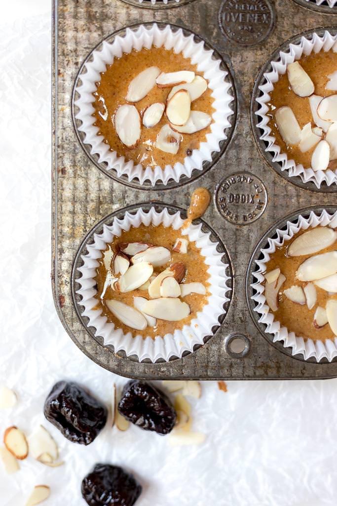 over head photo of almond butter cups in muffin tin with prunes on the side