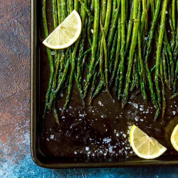 oven roasted asparagus recipe on baking sheet with lemon slices