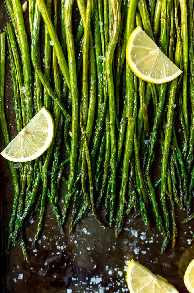 final photo of oven roasted asparagus recipe, close up with lemon wedges on asparagus