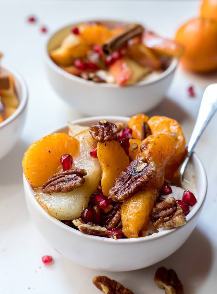 small bowl of yogurt topped with bakes apples, pears and mandarins