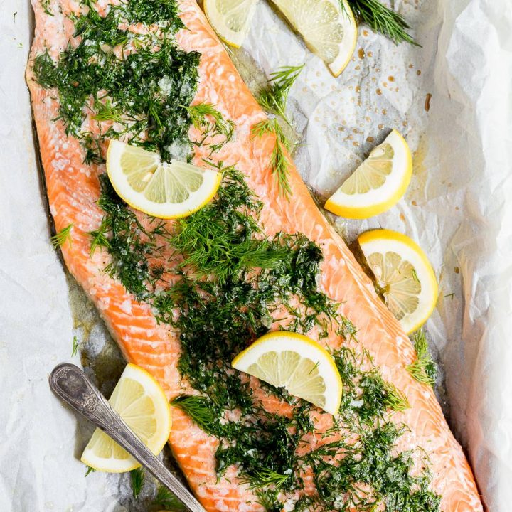 fresh out of the oven, baked salmon topped with fresh dill and lemons
