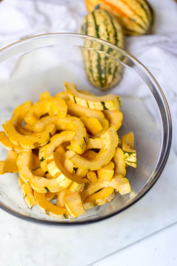 delicata squash that is sliced and prepared for roasted delicate squash recipe
