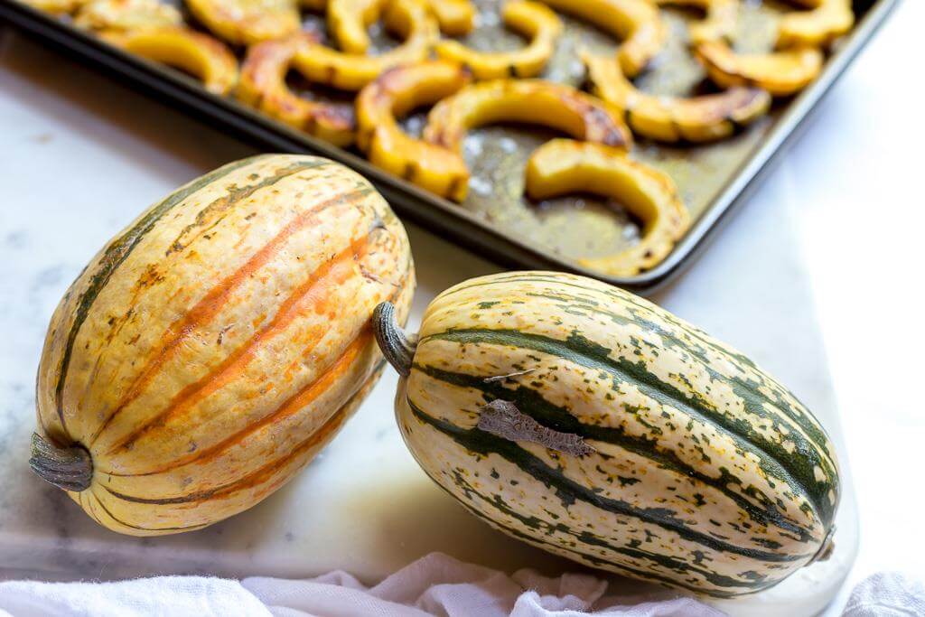 two whole delicata squash before being sliced and roasted