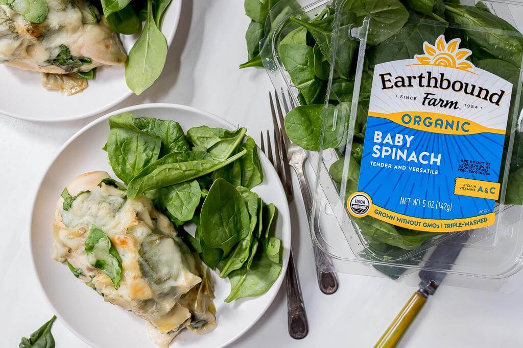 plated smothered chicken with package of Earthbound Farm Baby Spinach on the side