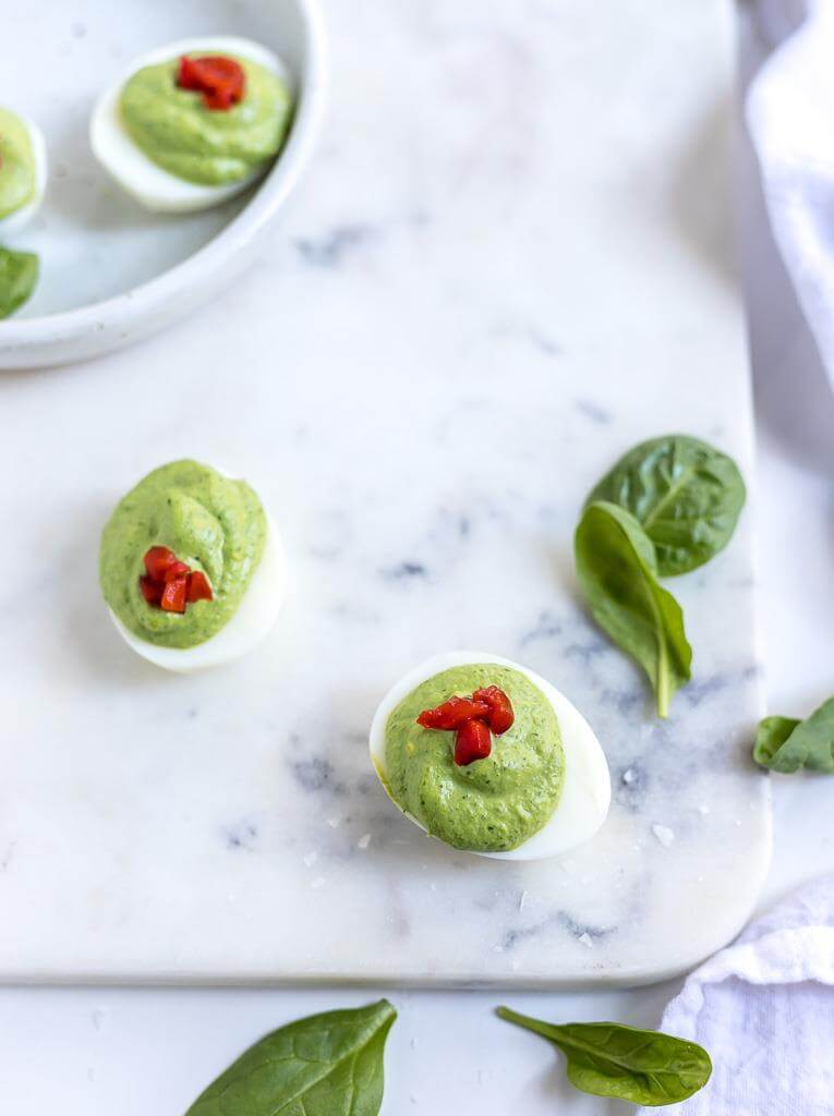 holiday deviled egg recipe on white marble tray