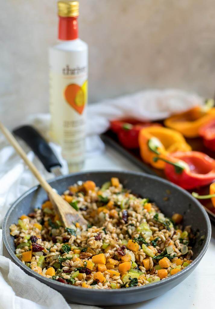 stuffed peppers recipe filling in skillet with prepared peppers in the background