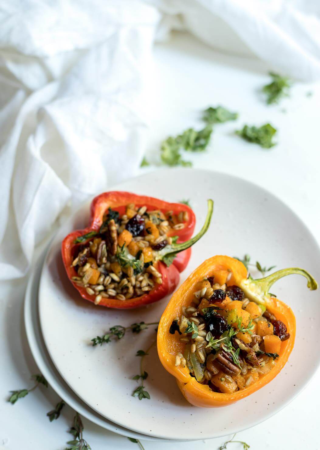 farro salad stuffed peppers recipe on white plates with white background