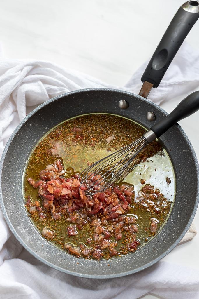 Warm Bacon Dressing in sauce pan with whisk