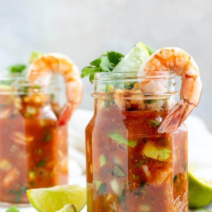 mexican shrimp cocktail served in glass jars, limes on the side