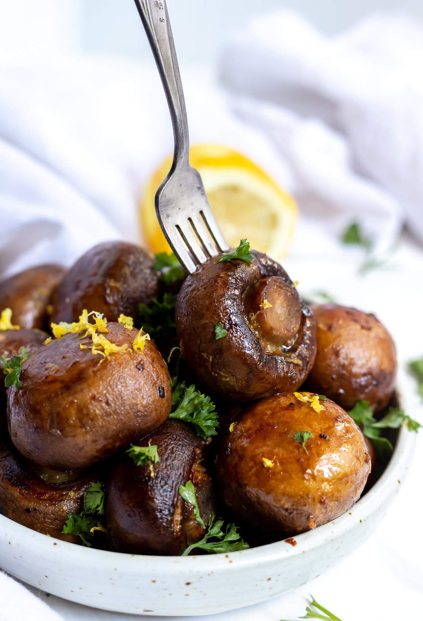 roasted lemon garlic mushrooms being stabbed with a fork