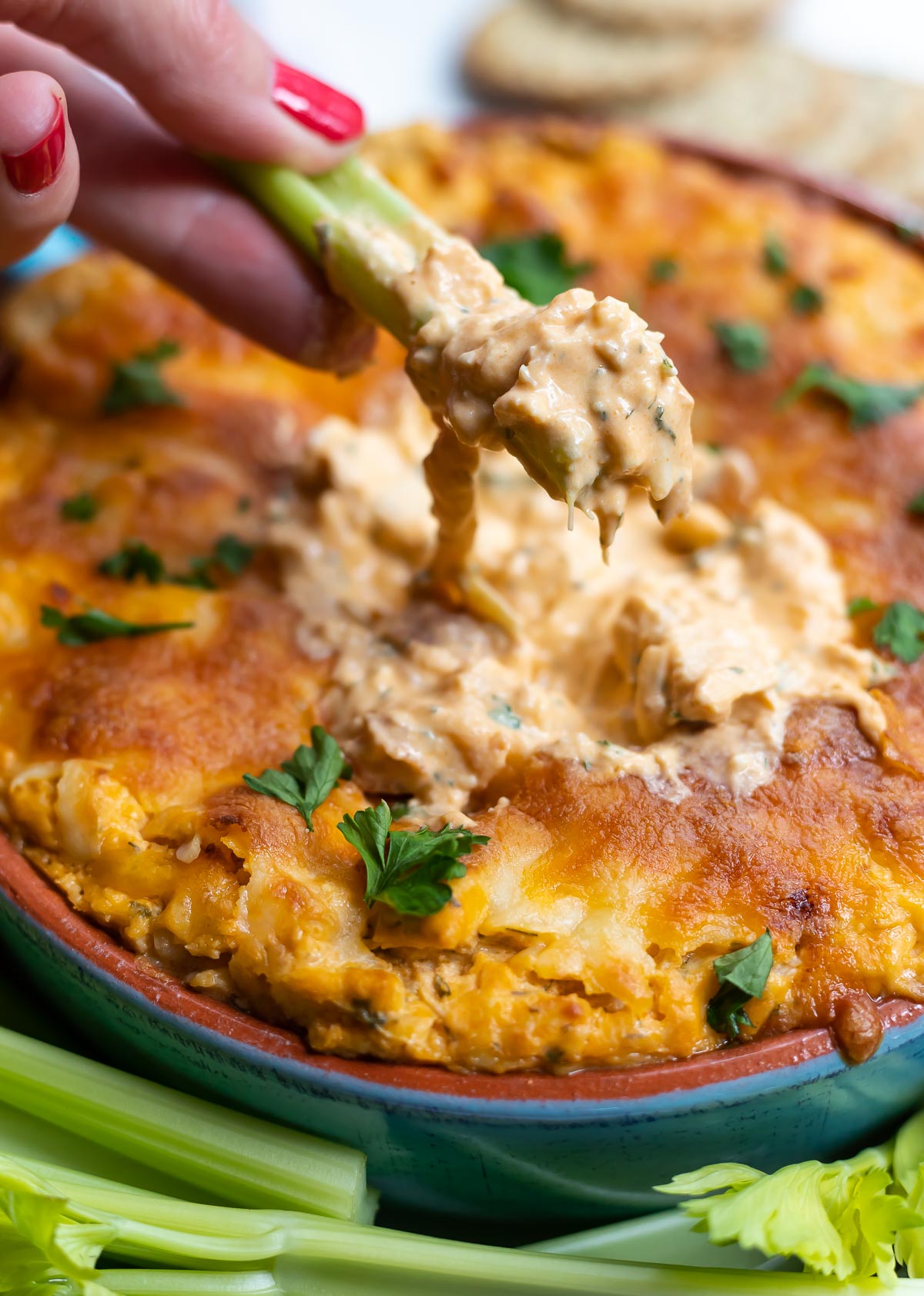 dipping celery into buffalo chicken dip