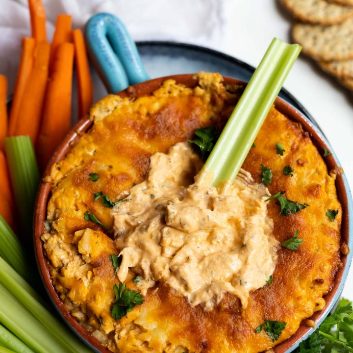 buffalo chicken dip with crackers, celery and carrots on the side