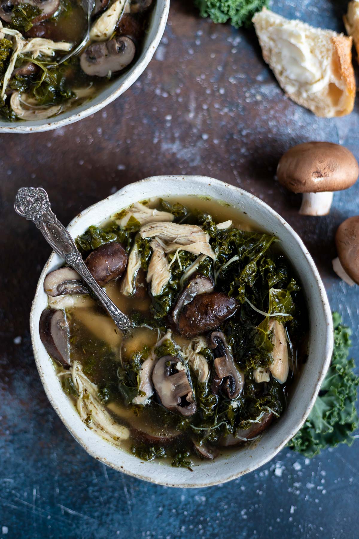 bowl of instant pot chicken soup with mushroom, kale and a golden broth