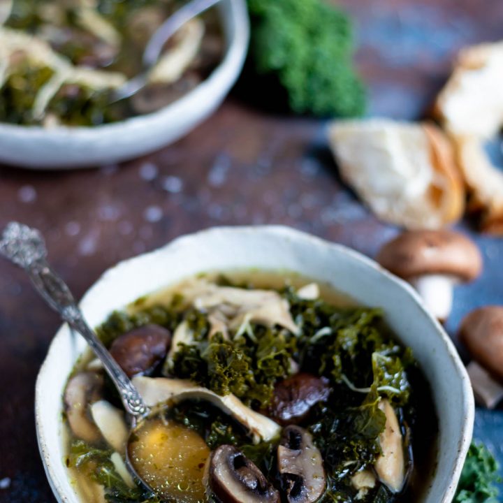 mushroom kale instant pot chicken soup in white bowl with bread on the side