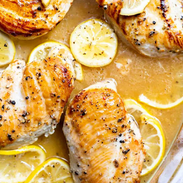 golden brown lemon pepper chicken with sliced lemons