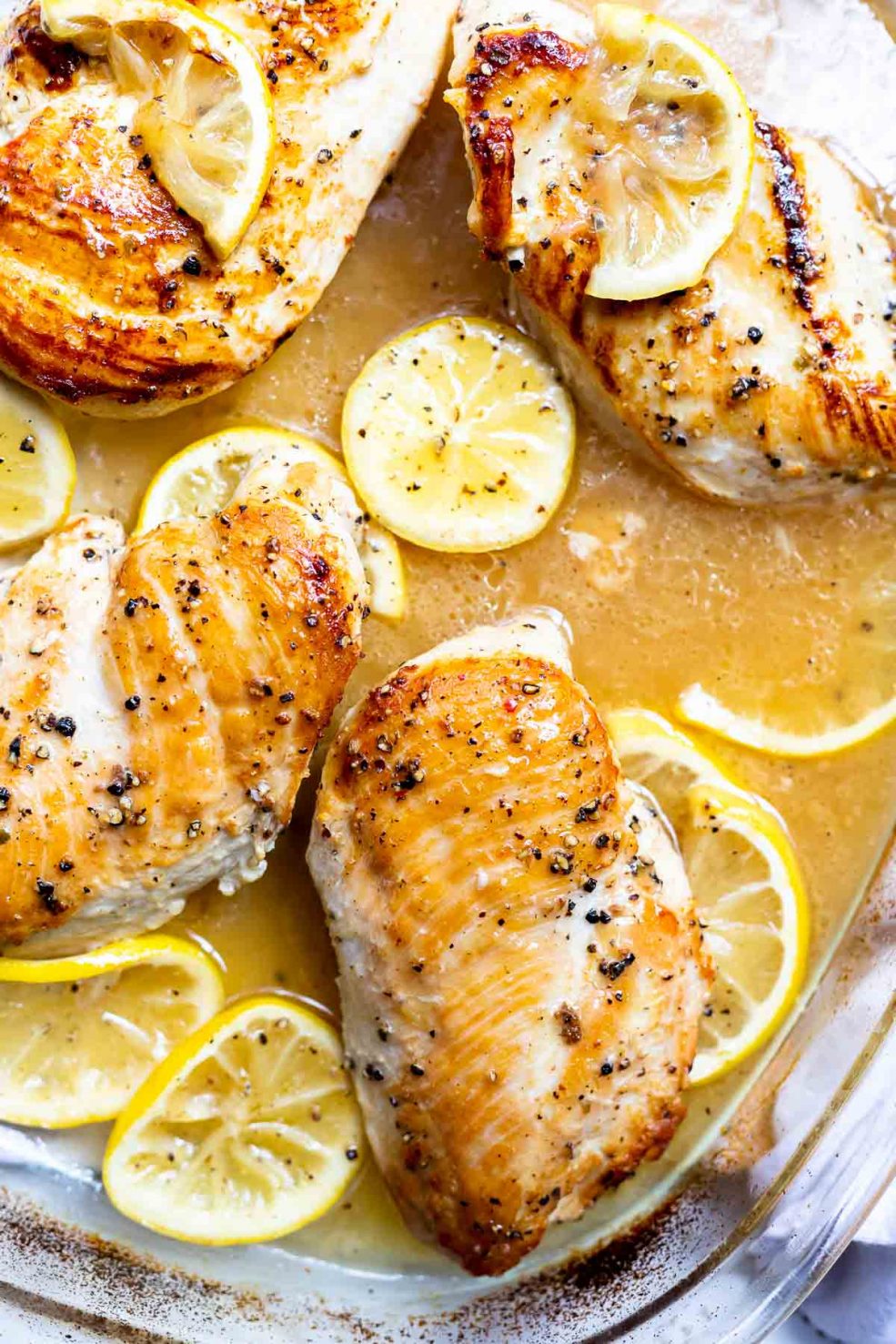 golden brown lemon pepper chicken with sliced lemons