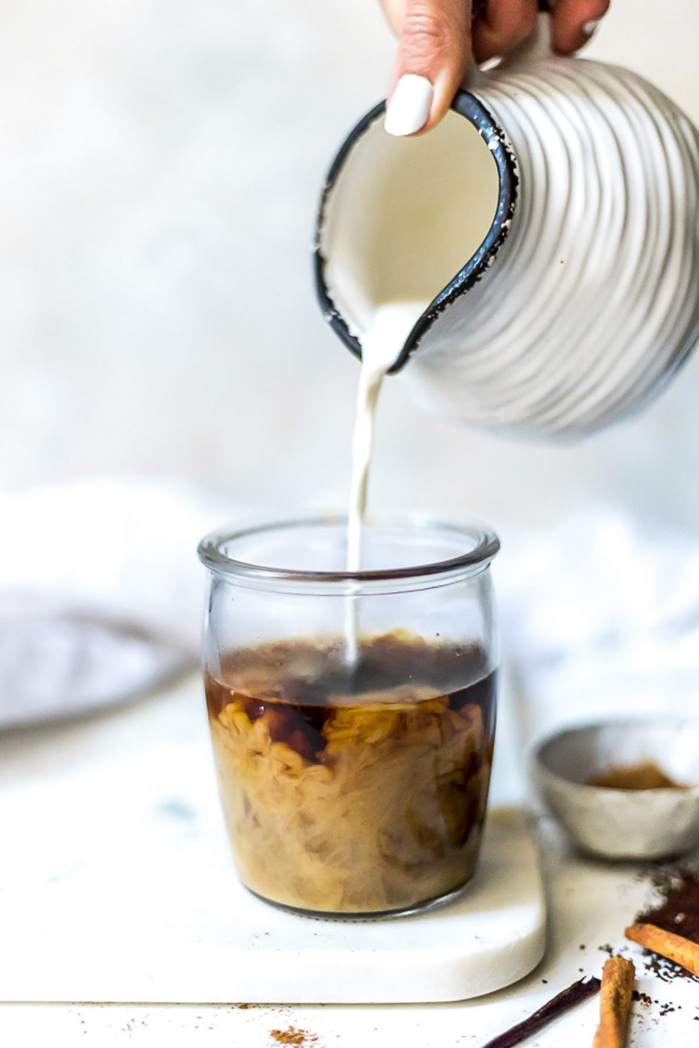 paleo vegan coffee creamer being poured into clear glass of coffee