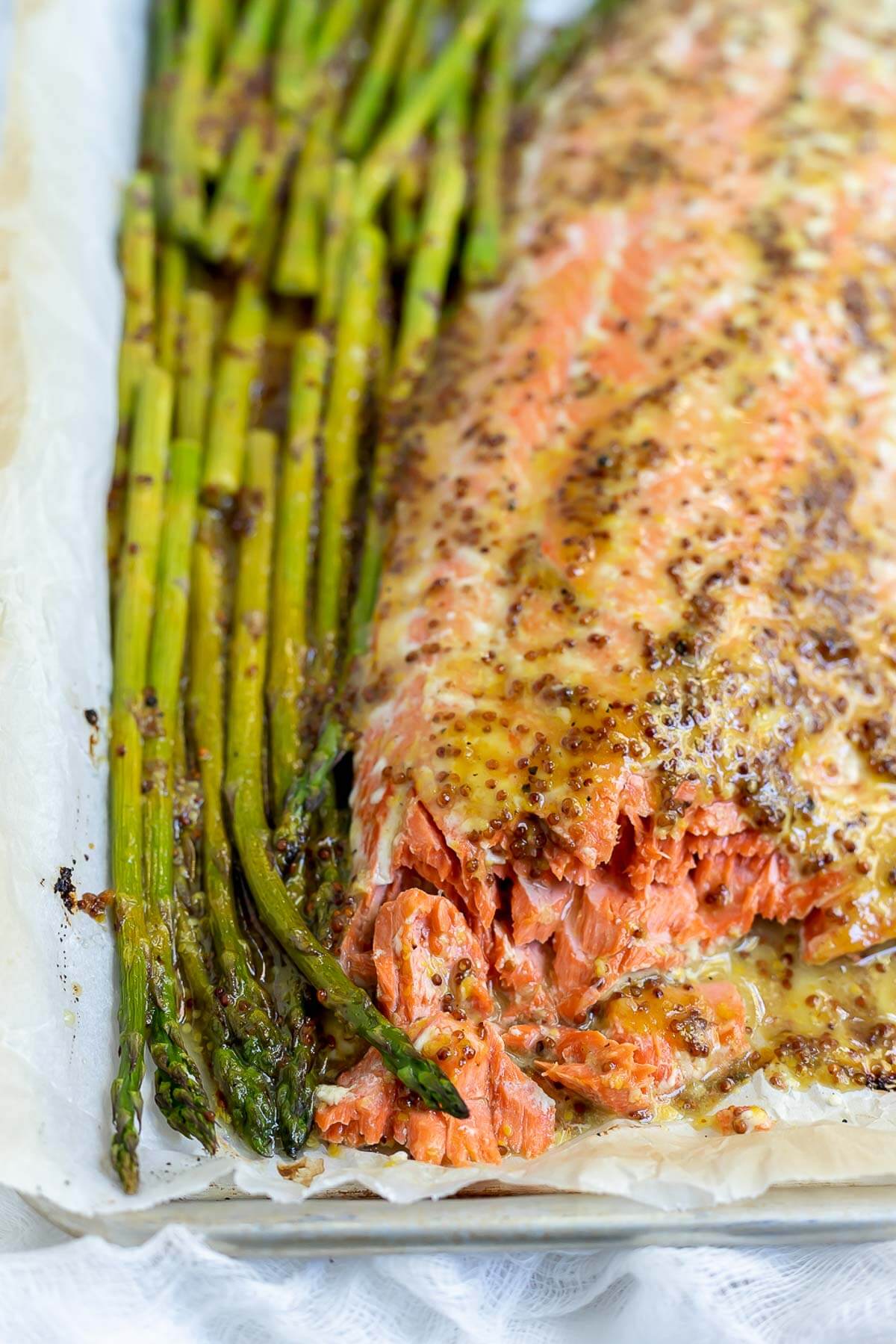 baked salmon asparagus on a parchment lined sheet pan