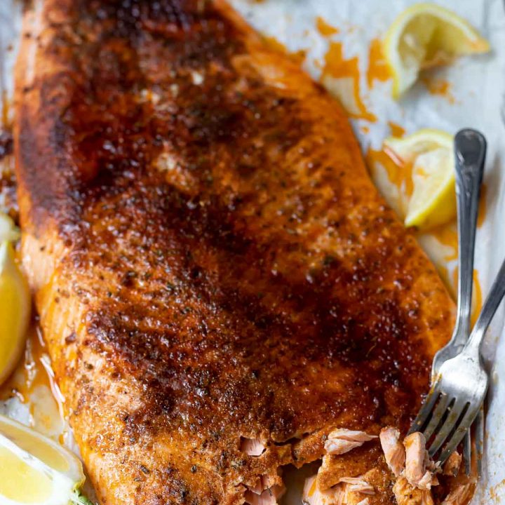 oven baked blackened salmon covered on spices and served with lemon wedges