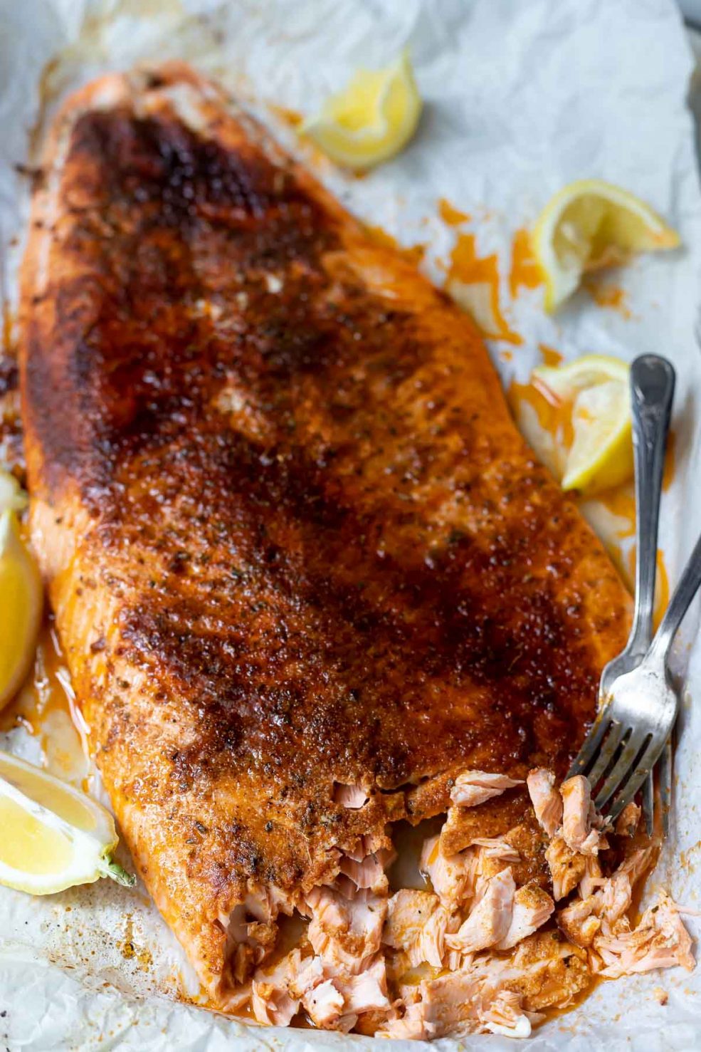 oven baked blackened salmon covered on spices and served with lemon wedges