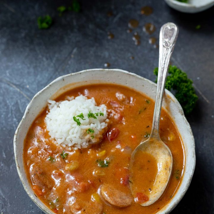 chicken and sausage gumbo in white bowl with spoon