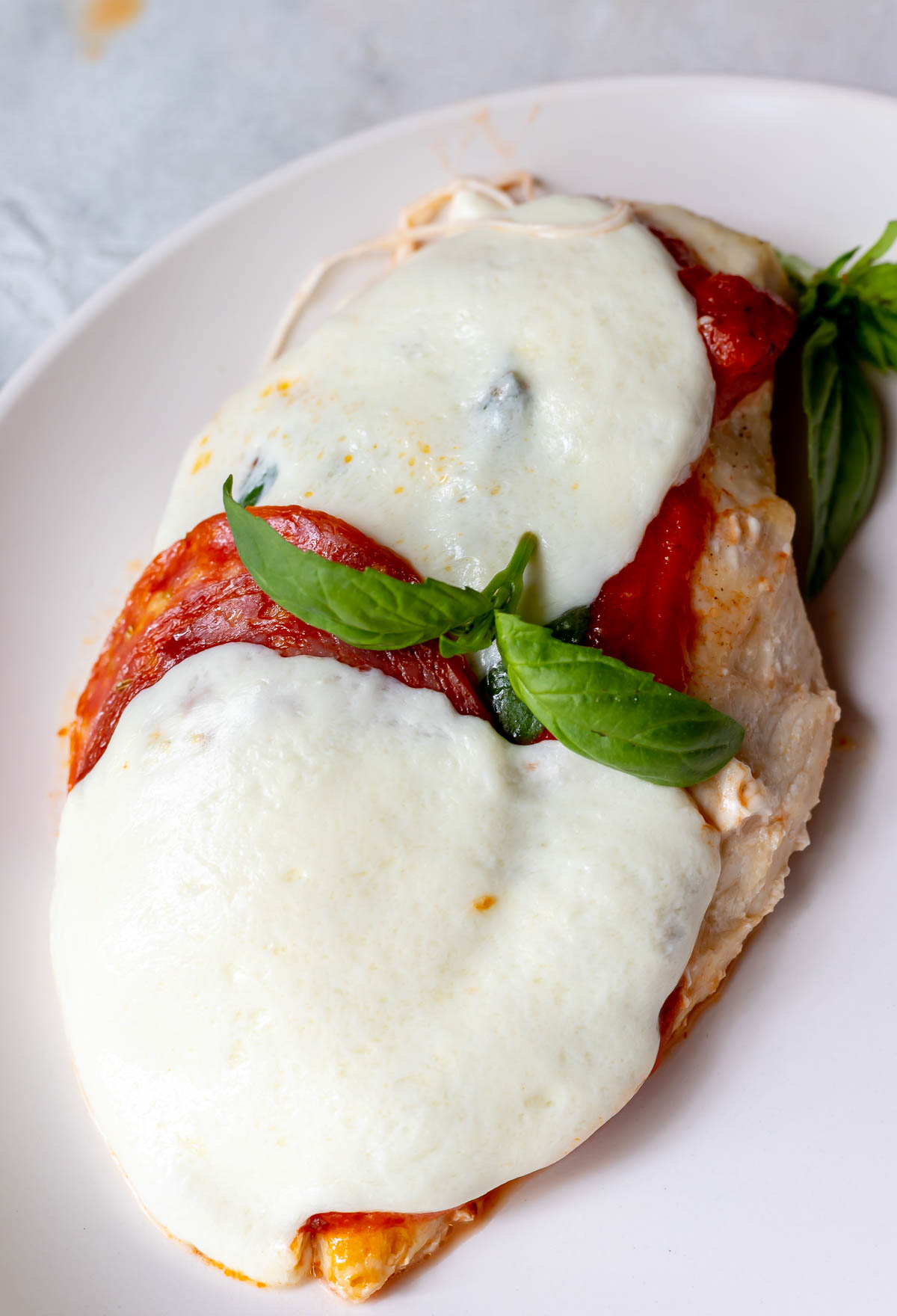pizza chicken breast smothered with mozzarella and pepperoni, topped with basil leaves