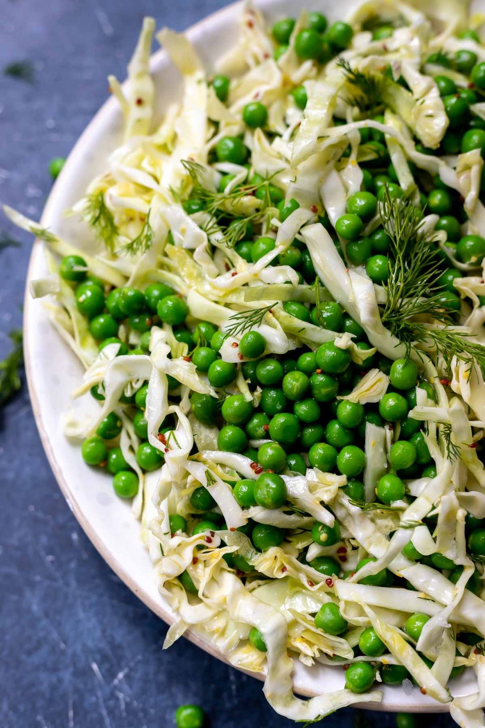 english peas and shredded cabbage in a white bowl