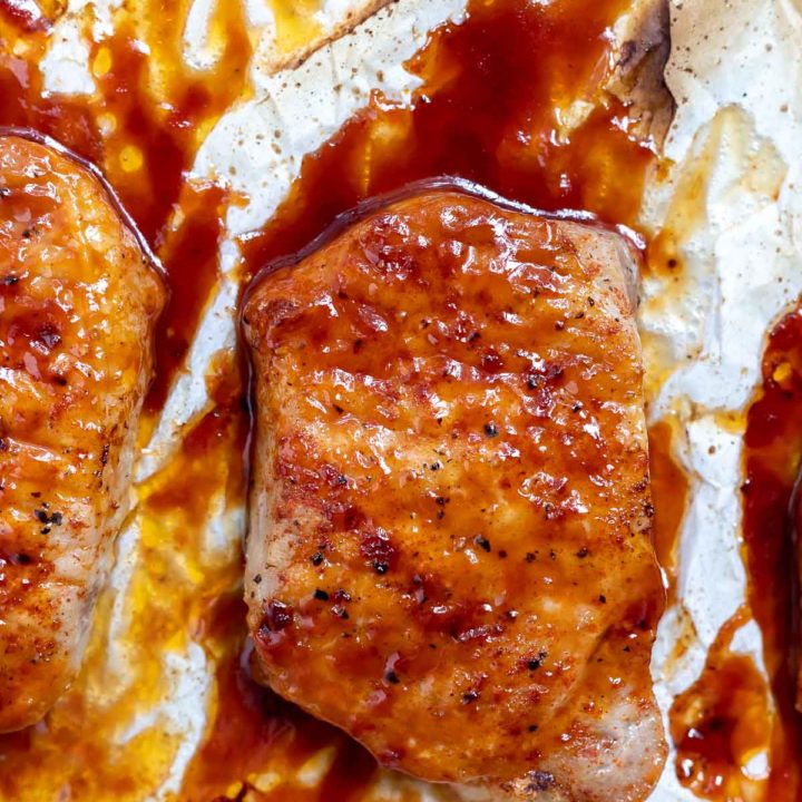 baked pork chop slathered with bbq sauce on parchment paper