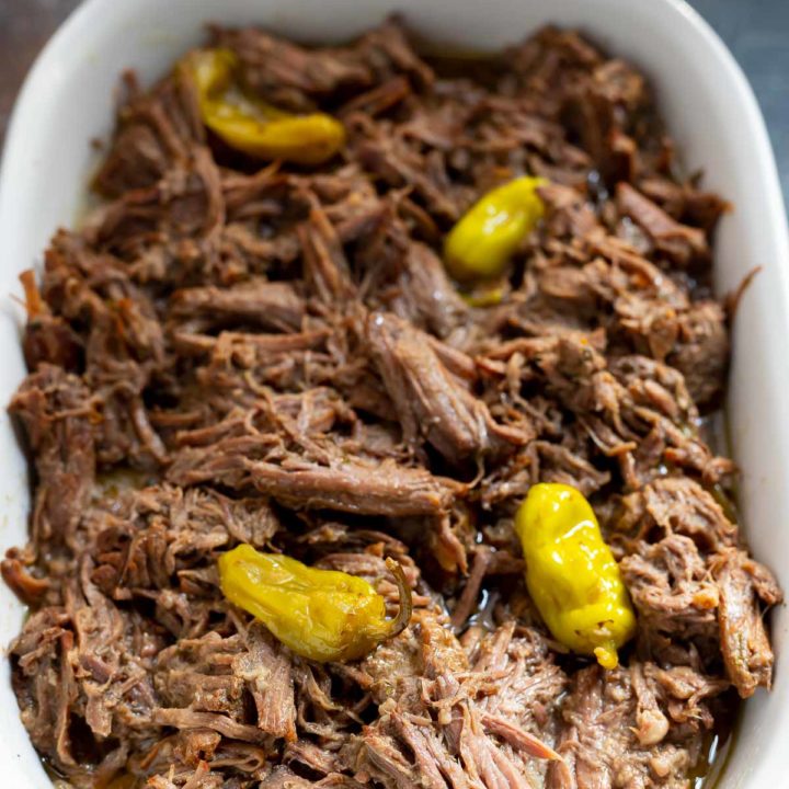 shredded beef pot roast in white serving dish
