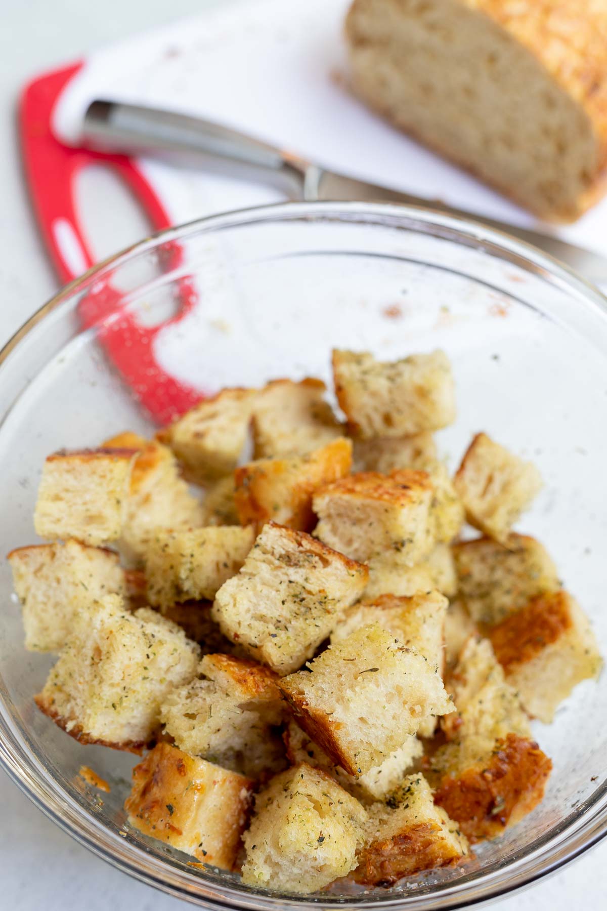 cubed bread in clear bowl with bread loaf in the background