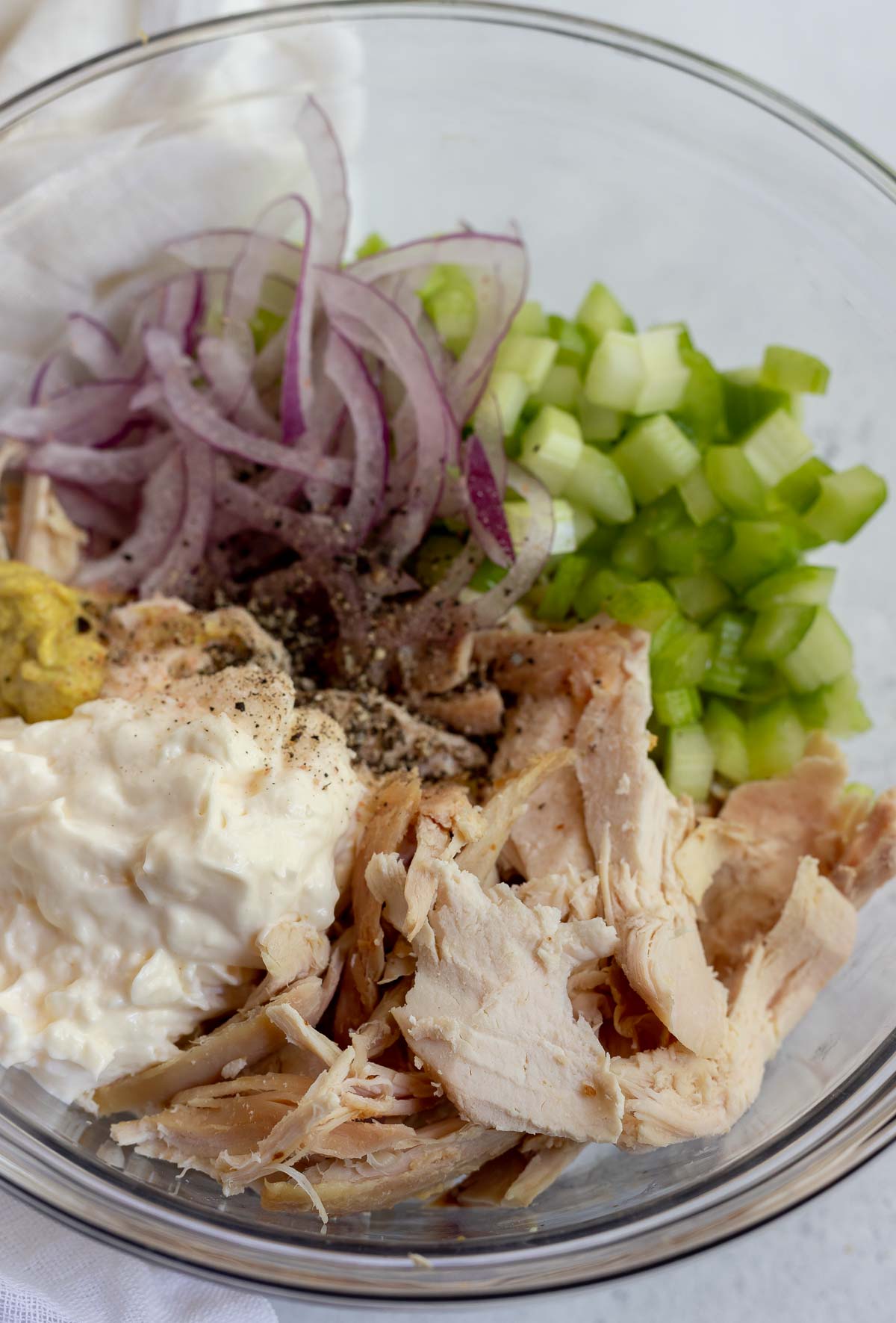 ingredients for chicken salad made with rotisserie chicken in glass bowl