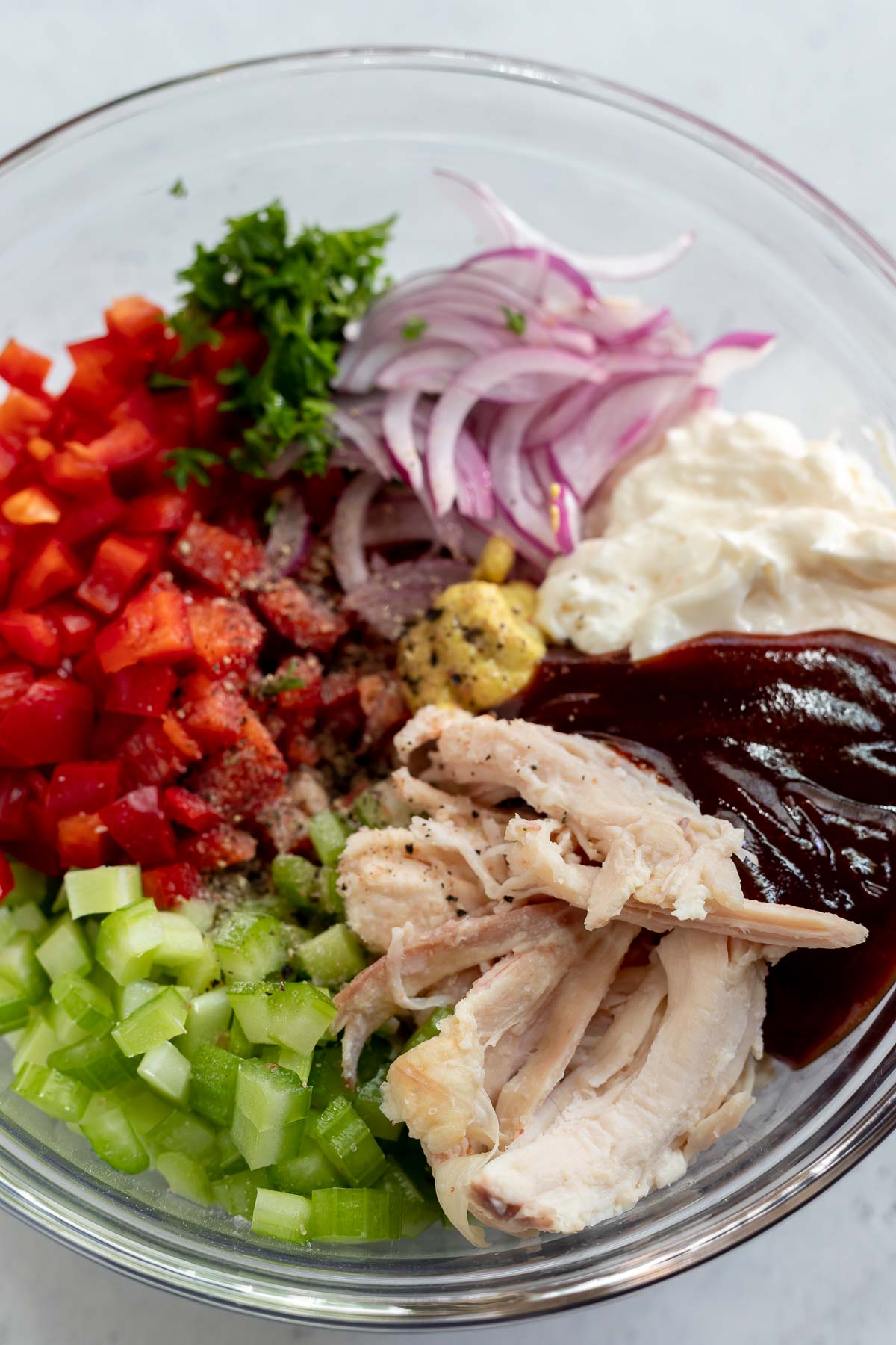 barbecue chicken salad ingredients in clear glass bowl