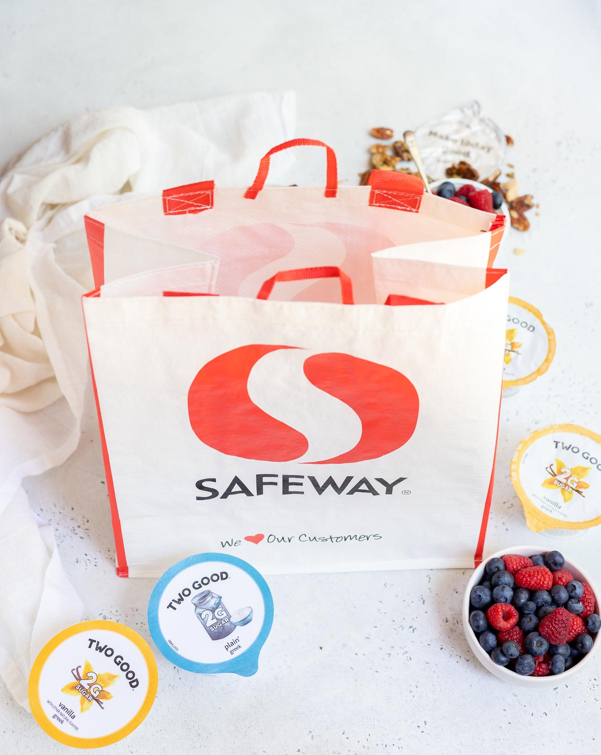 grocery bag next to granola and berries